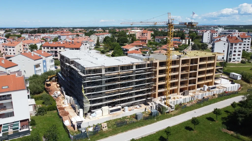 View of a multi-storey timber building construction site with a crane and the structural frame already in place